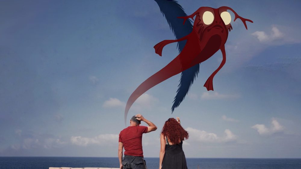 Two people on a seawall look up at a red animated sea creature in the sky
